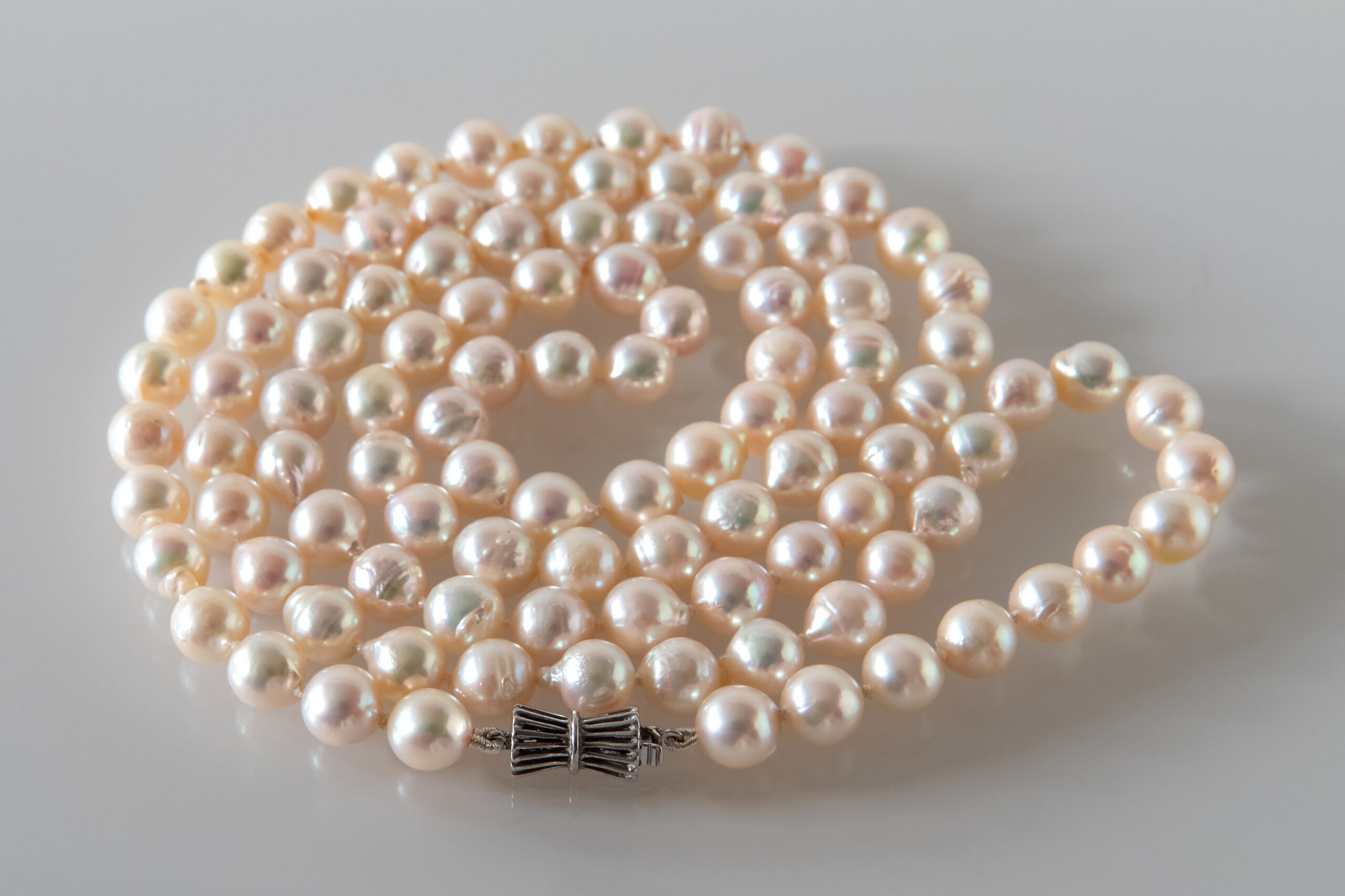 Fermoir en argent fermant un long collier de perles de culture baroques nouées sur soie